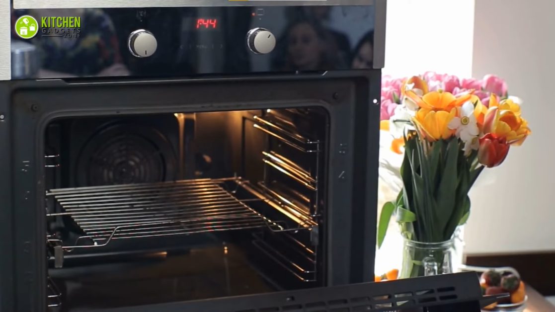 electric oven and a flower vase beside