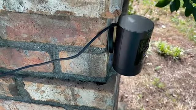 ring stick camera mounted on brick wall outside
