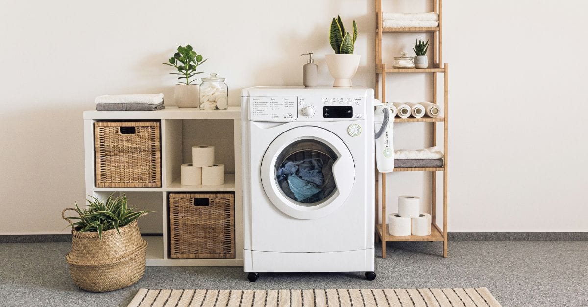 A laundry room with washing machine and shelves