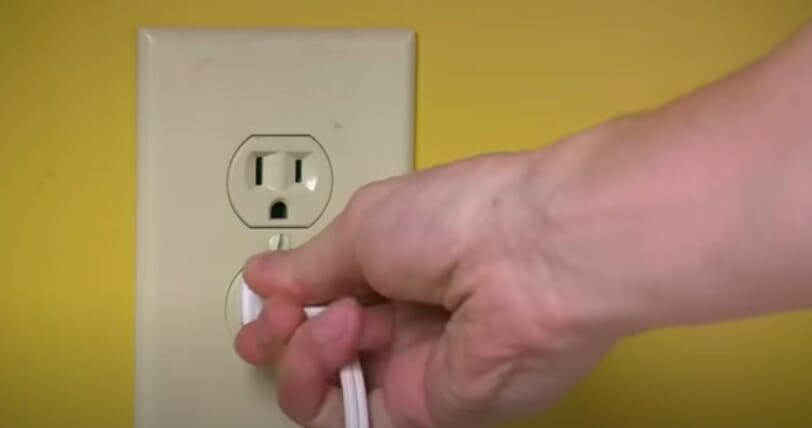 man plugging into an outlet
