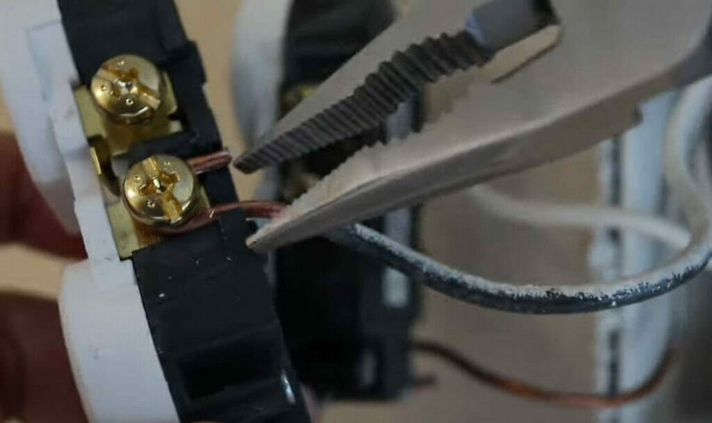 attaching black hot wire to the brass terminal