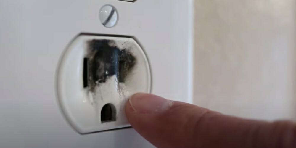 burnt outlet pointed by a finger