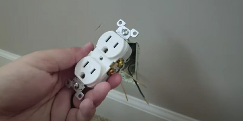 left hand holding an outlet