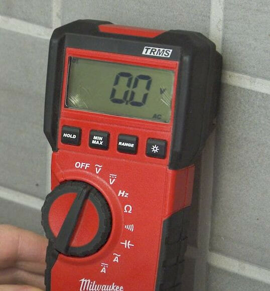 A person is setting the multimeter to AC