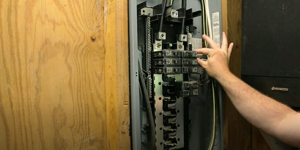 a hand pulling a breaker on the electrical box