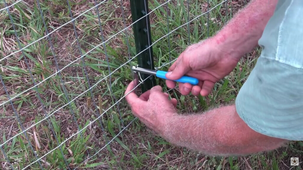 man installing wire fences