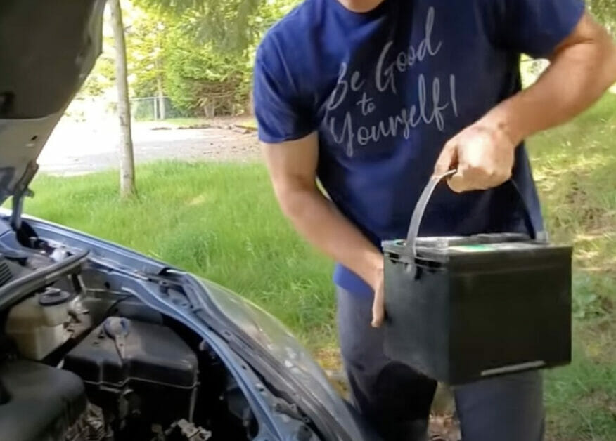 man replacing his car battery