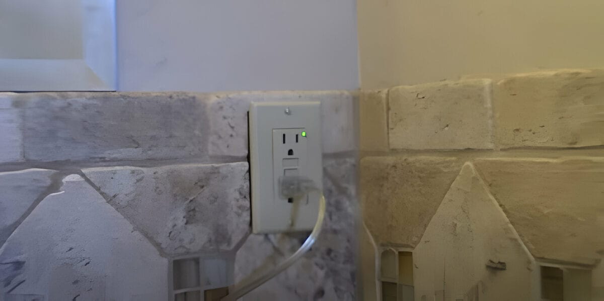 A GFCI outlet mounted on a marble tile