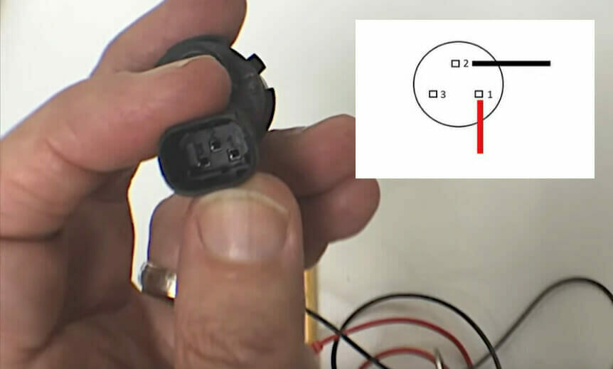 a hand holding a pin of a 3-contact sensor