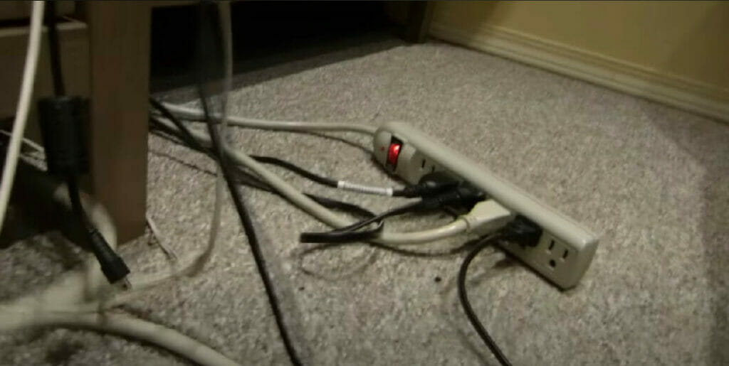 a loaded electrical outlet extension on the floor