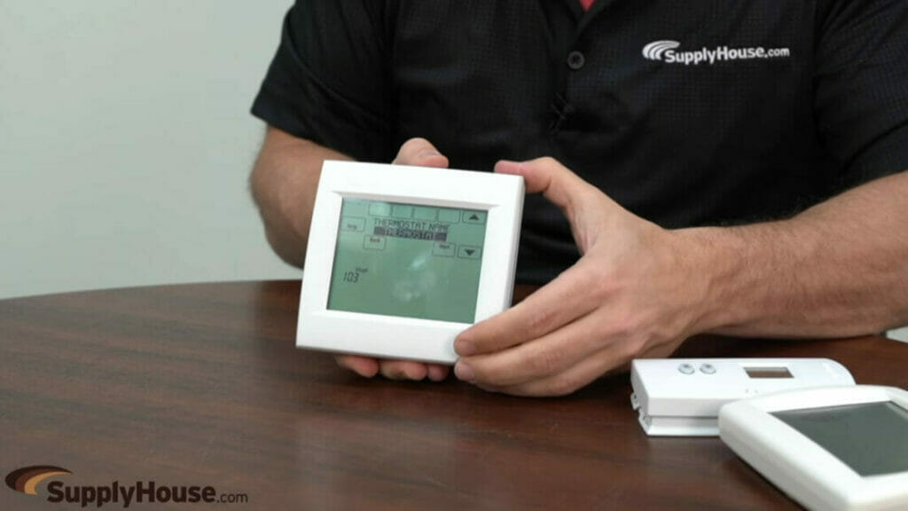 a man at supplyhouse.com showing a thermostat