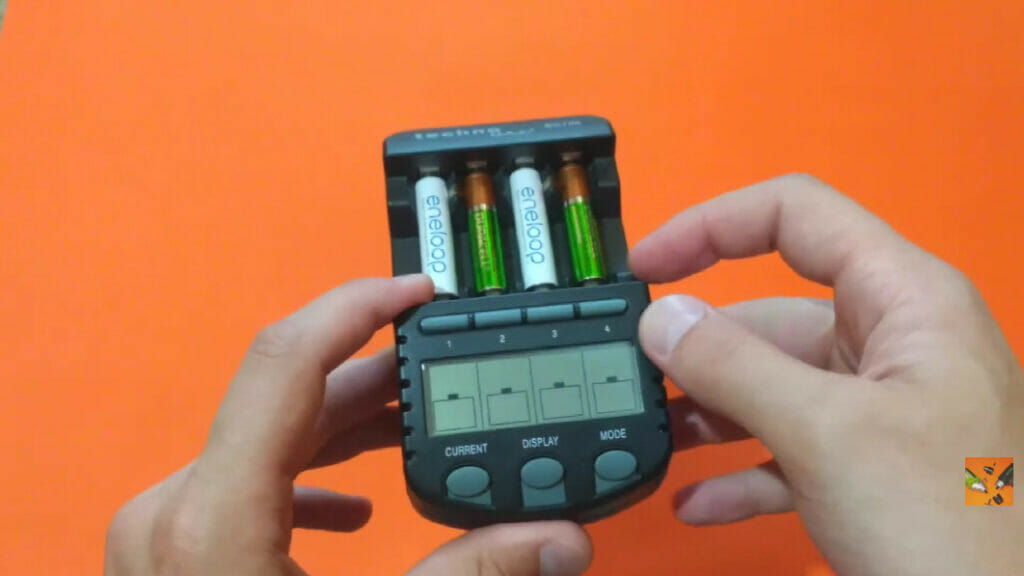 a man's hand holding a device with 4 aaa batteries