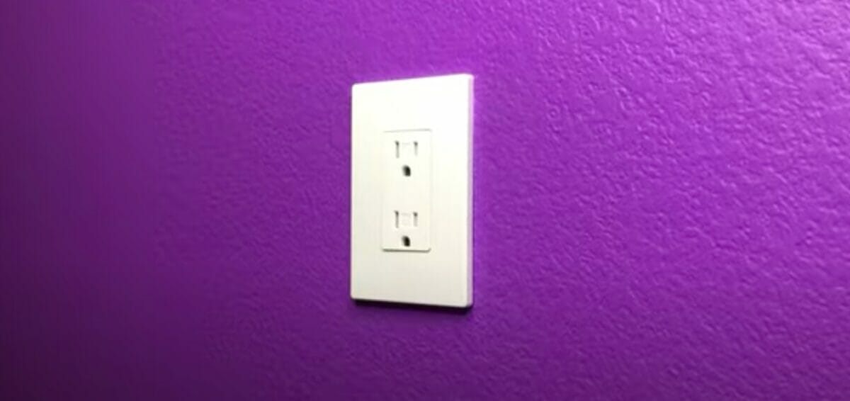 a two-prong outlet in a purple wall