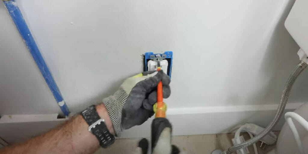 an electrician installing an outlet in the bathroom