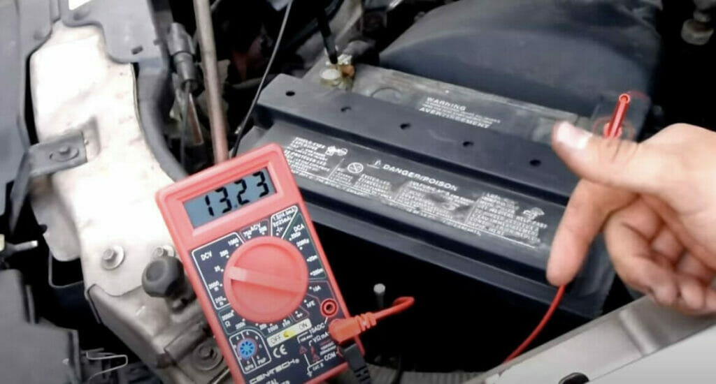 man checking car battery voltage using a multimeter