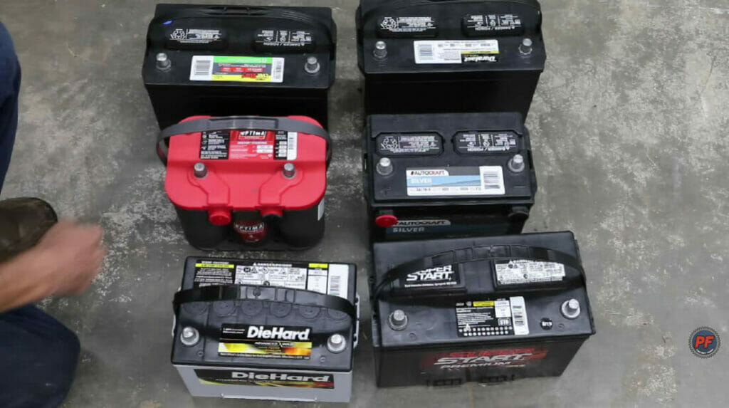 man checking up on 6 car batteries