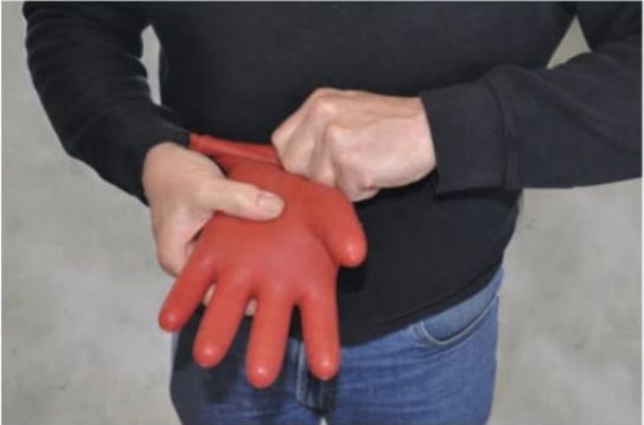 man doing inflation testing for an air leak of an insulating gloves
