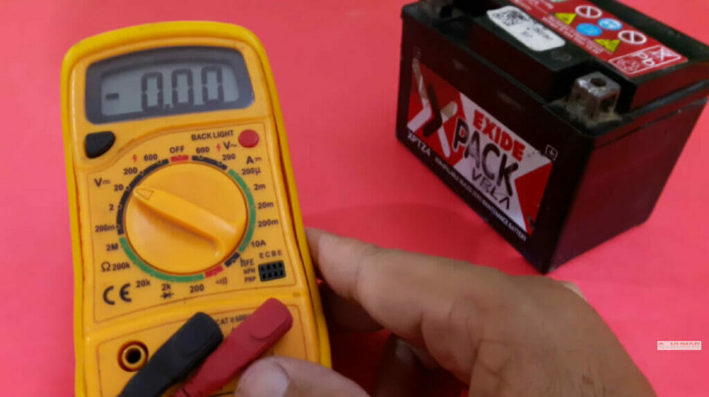 man holding a multimeter in preparation for battery testing