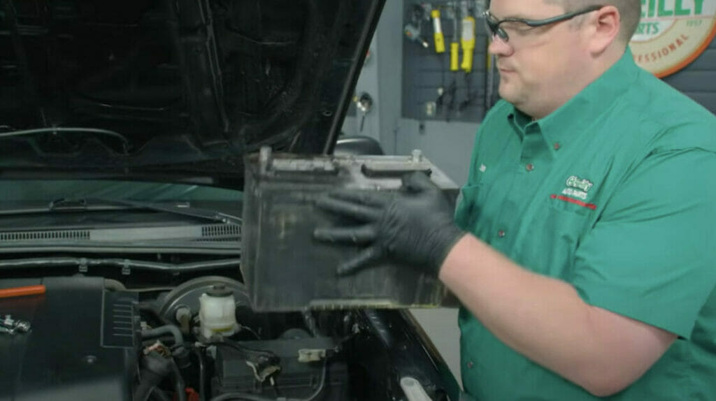 man removing his car's old battery