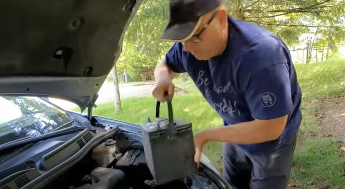 man replacing his auto car battery
