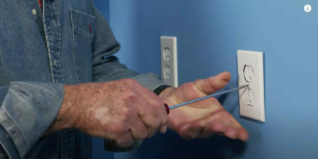 man using screwdriver opening an outlet cover