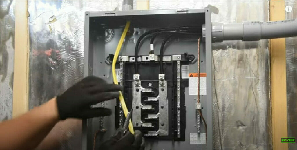 man wearing a black gloves working on an electrical main panel