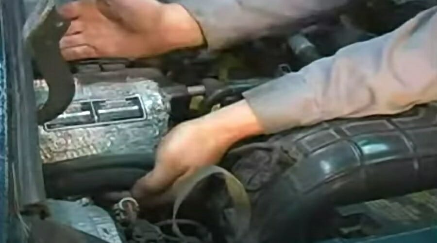 mechanic tracing hoses to find inlet and outlet of car's heater core