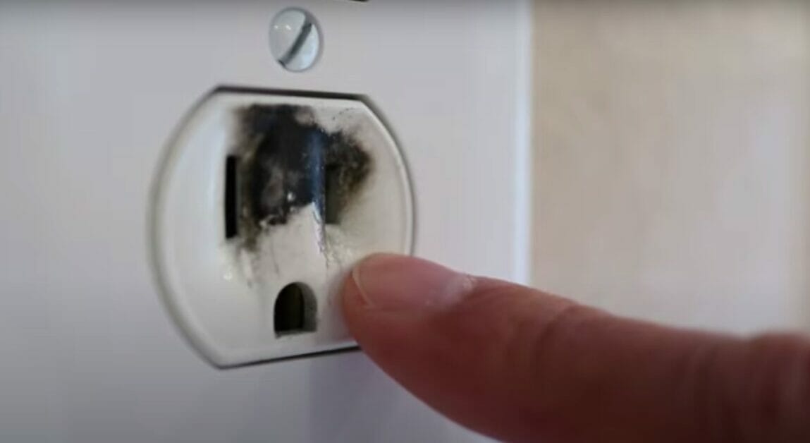 pointer finger pointing on a burnt outlet slot