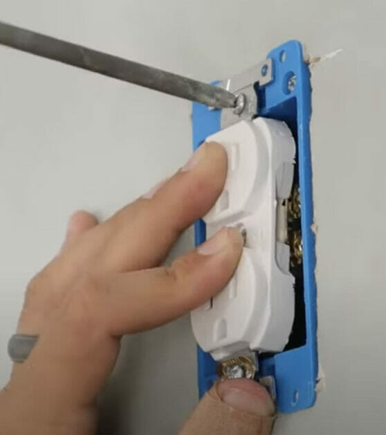screwing the outlet into place
