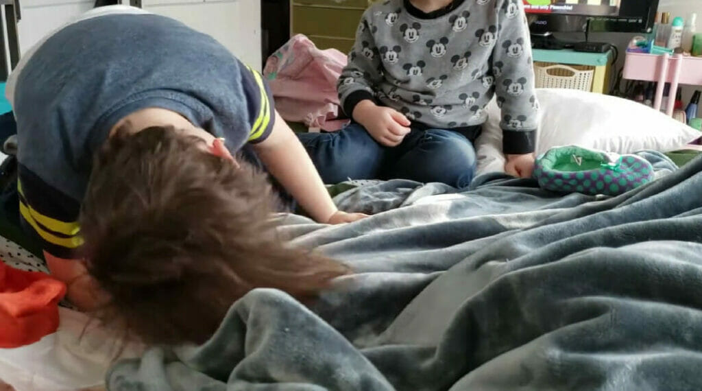 two children playing on the bed