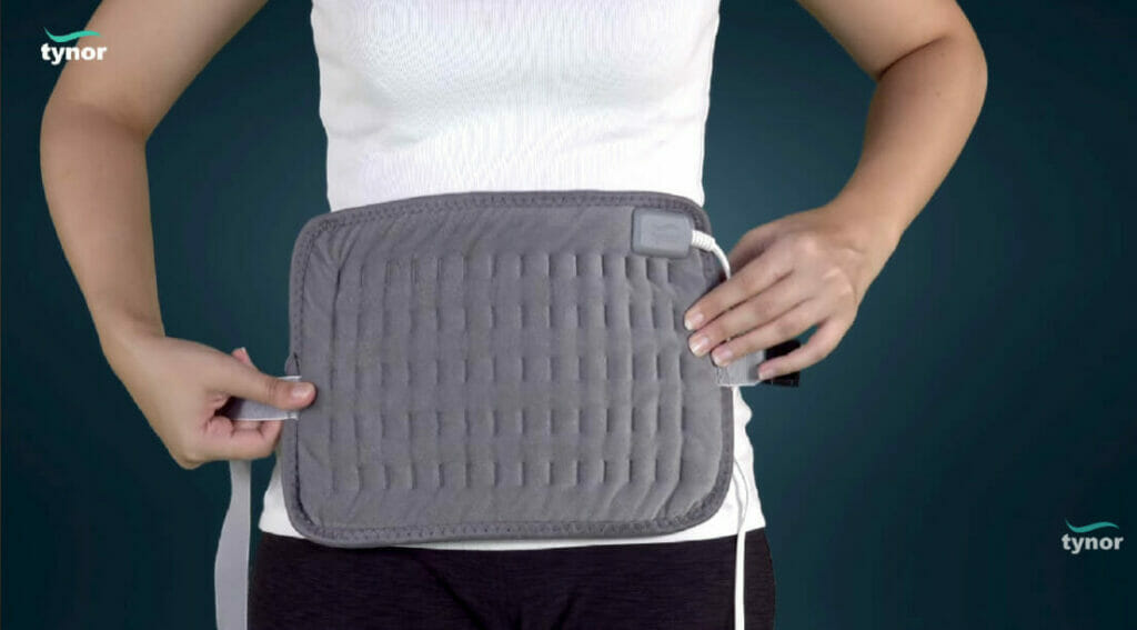 woman putting hot pad on her tummy area