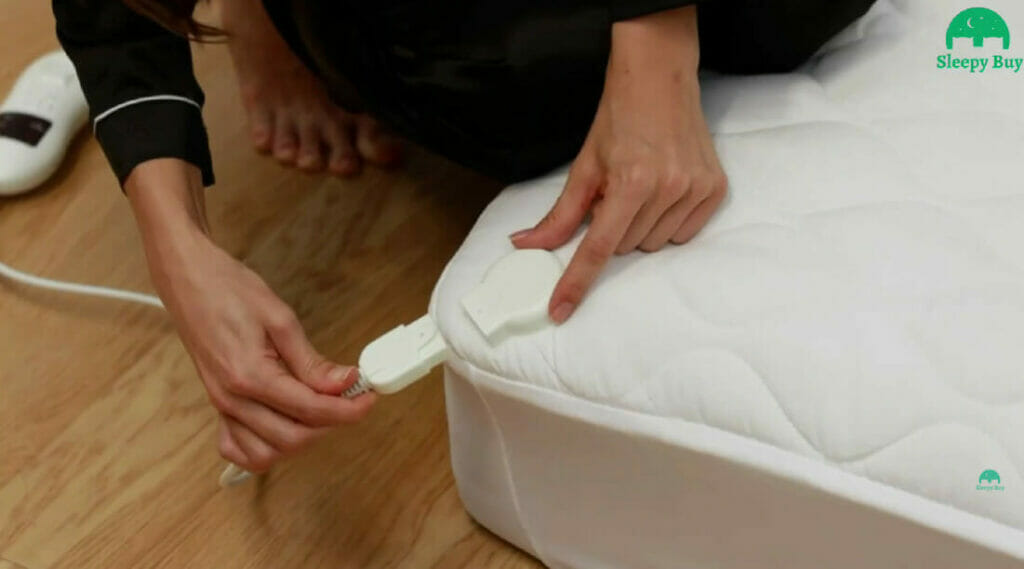 woman's hand plugging/unplugging the mattress heating pad