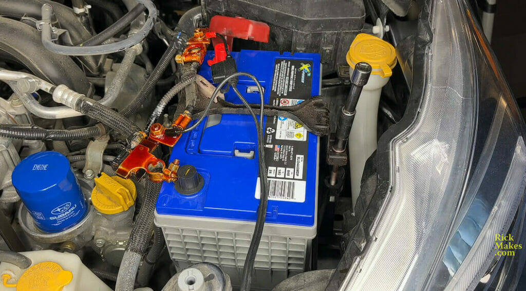 a blue cover battery in an open hood car