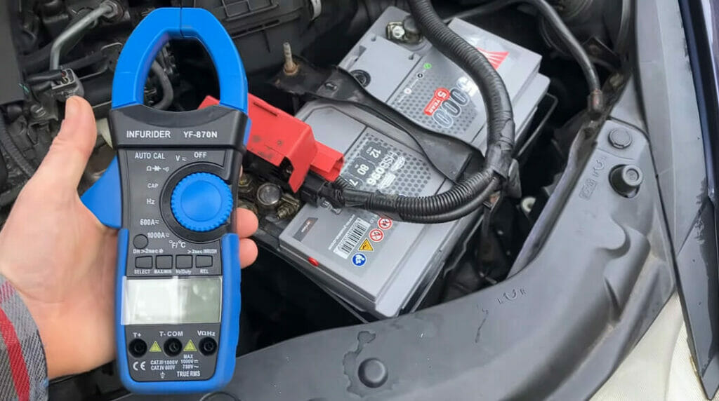 a voltmeter at the palm of a man's left hand while testing the car battery