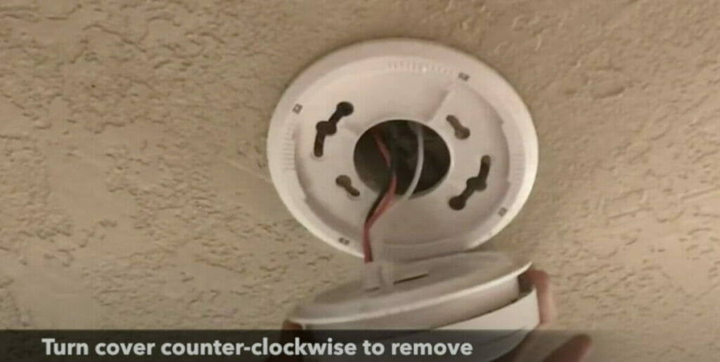 man turning cover counter-clockwise to remove