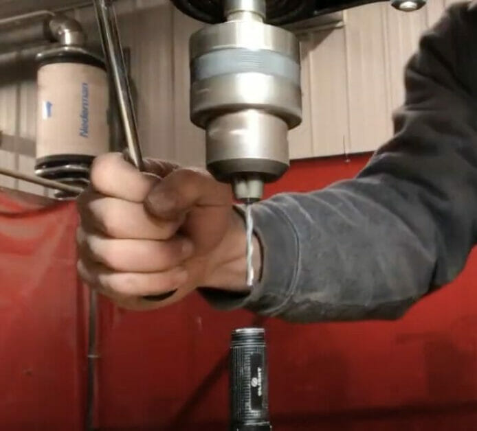 using a drill to hole the interior of the flashlight