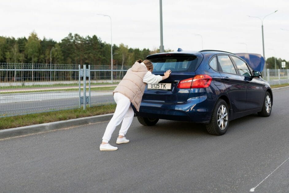 woman pushing her breakdown car on the street