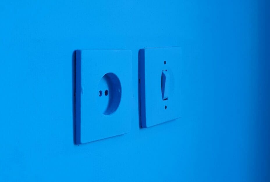 a blue led lit room focused on an outlet and a switch