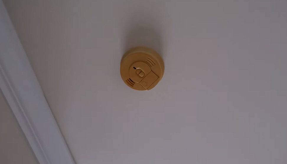 a brown color smoke detector on the ceiling