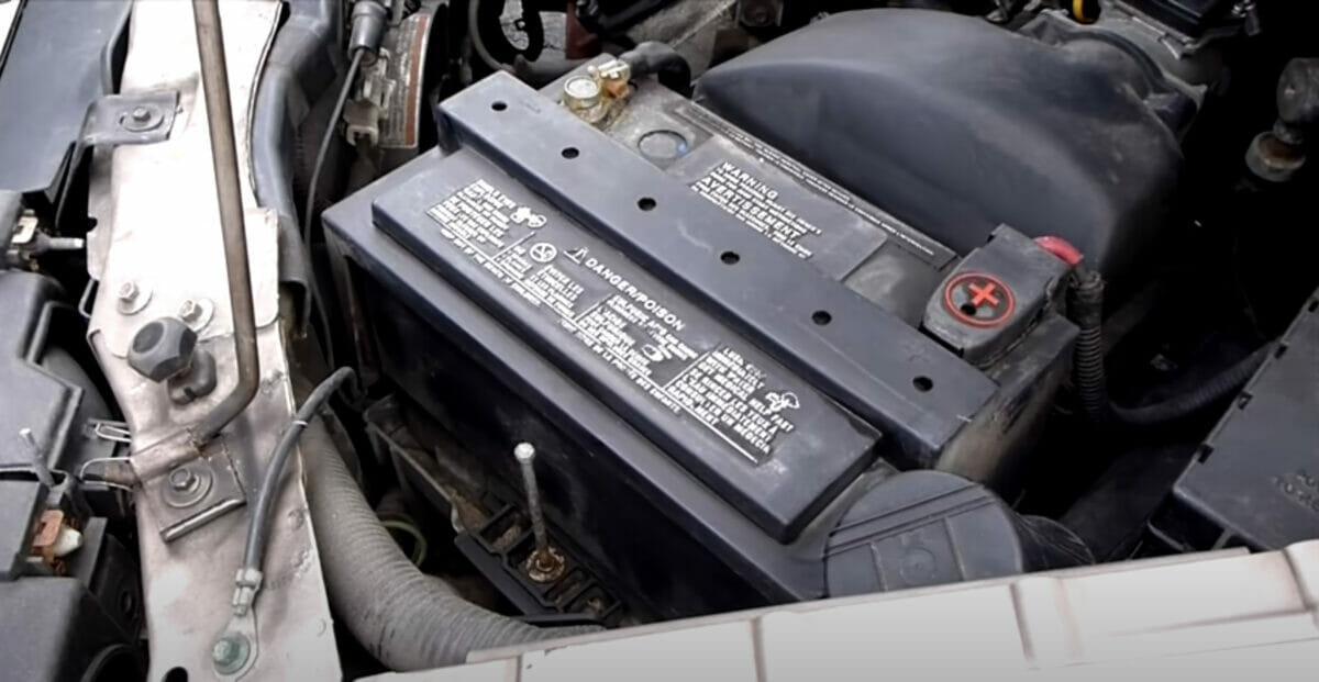 a zoom image of a battery in an open hood car engine