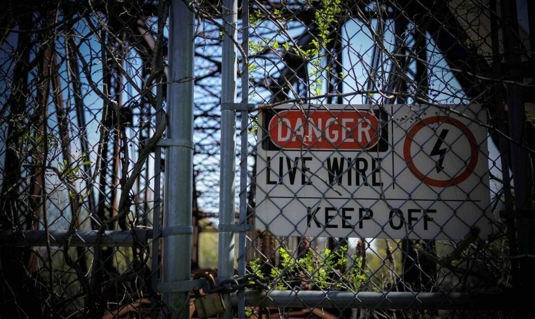 live wire warning sign on the fence
