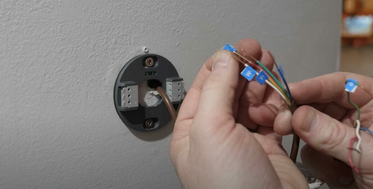 man doing a c wire installation on a nest thermostat