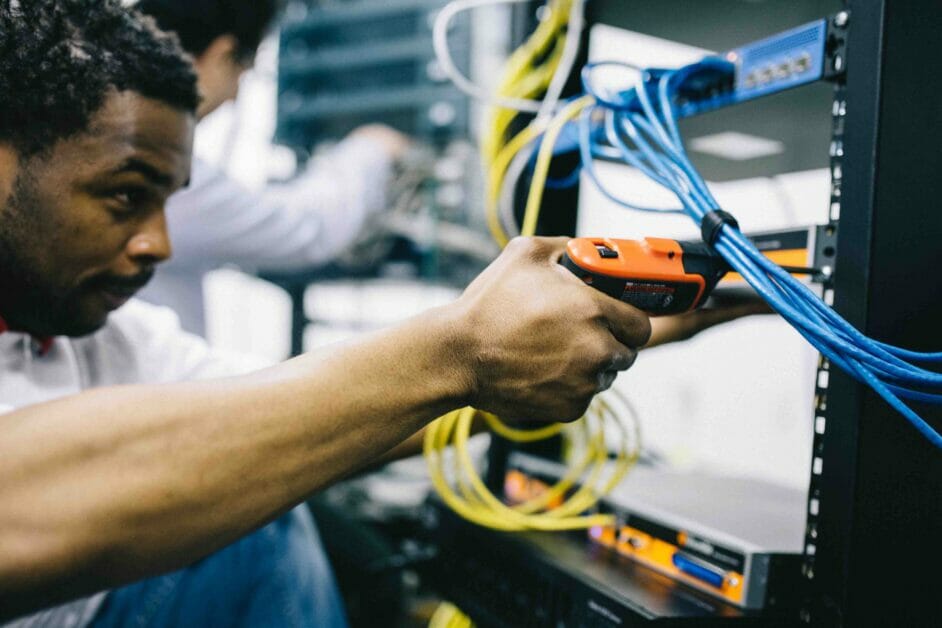 man fixing wires on a switch server