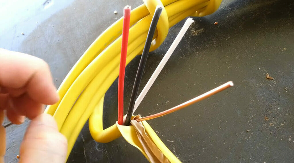 stripping romex wire to reveal red, black, white and orange wires
