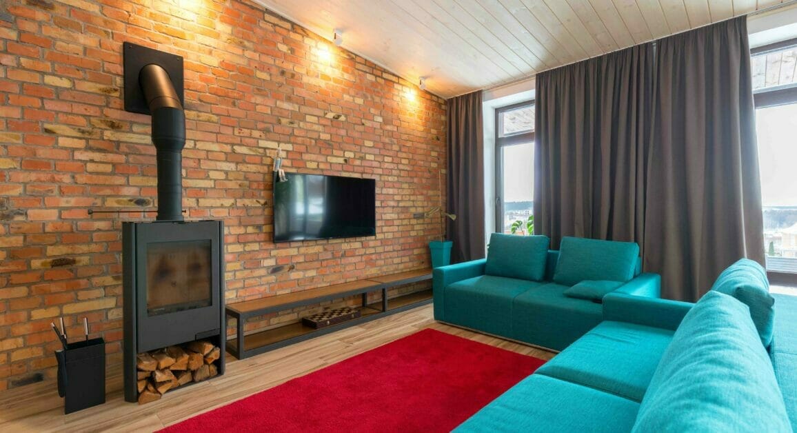 A living room with a brick wall and a fireplace, featuring clever solutions for hiding wires on the brick