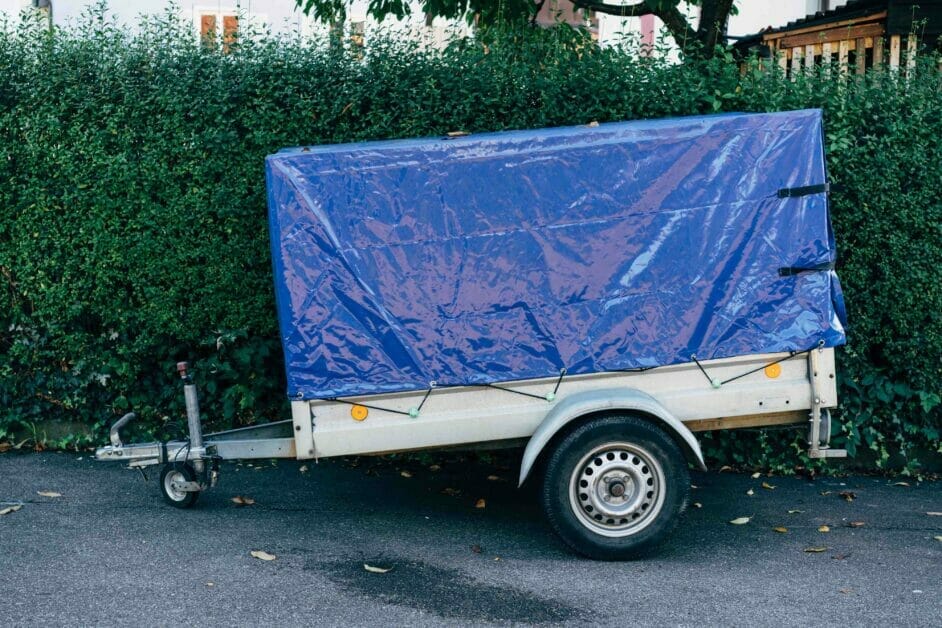 A trailer parked in front of a hedge