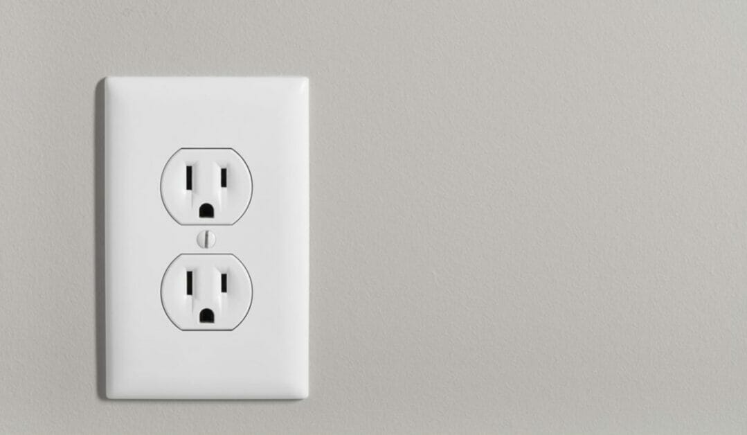 an outlet on a biege wall