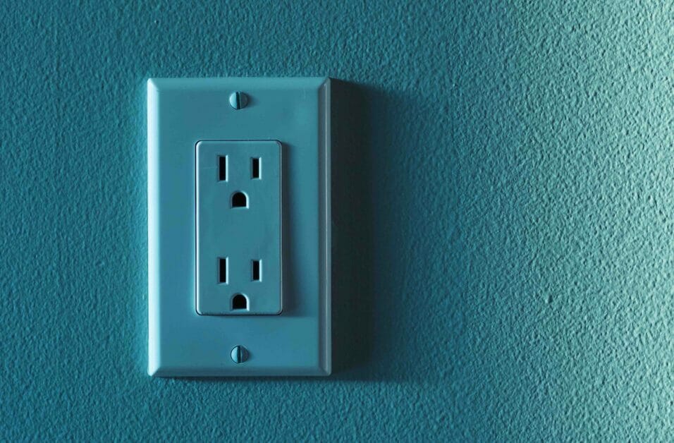 an outlet with two slots in a teal color matching the wall