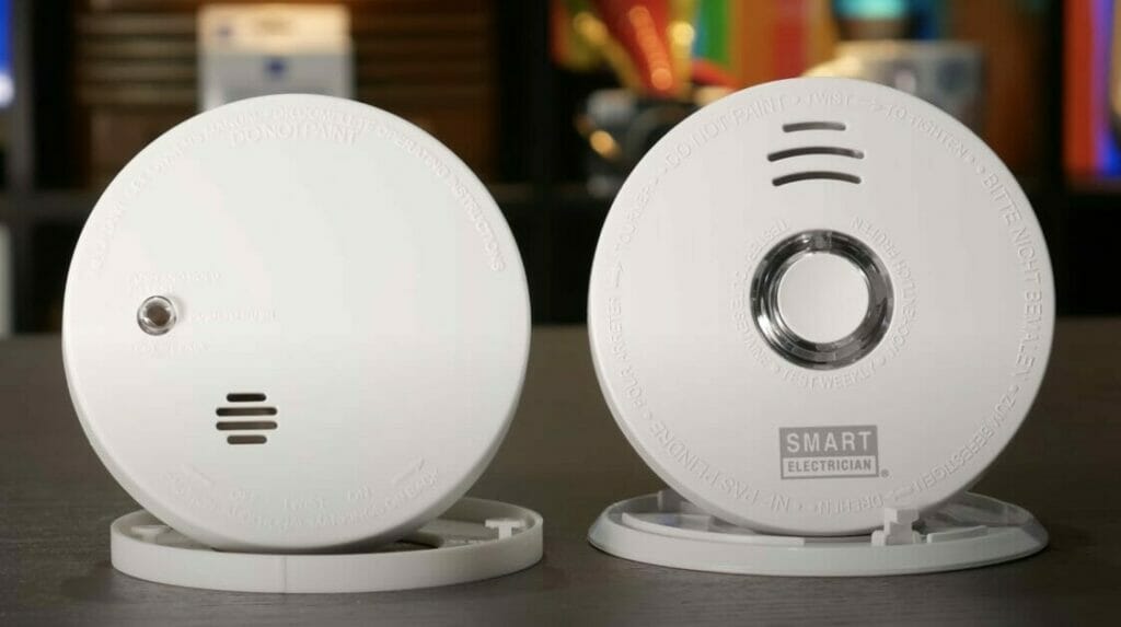 Two smoke detectors conveniently placed together on a tabletop