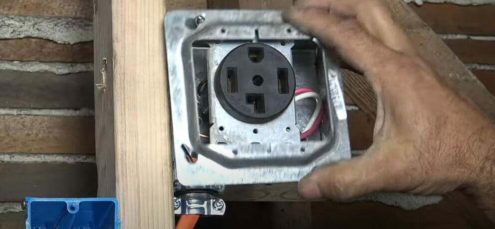 A man aligning and putting the cover plate into the metal box